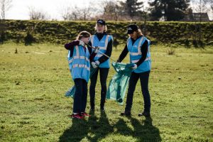 Vrijwilligers doen afval in zak tijdens Maas Cleanup